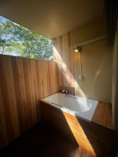 a large bath tub in a room with a window at 『花の影』カップル、ご友人、ご家族利用完全貸切!広々テラス露天風呂付!ポーラ美術館徒歩5分 in Hakone