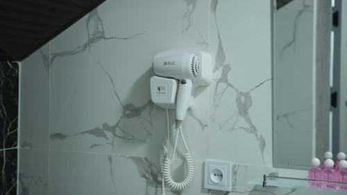 a bathroom with a blow dryer on a wall at Lotus Hotel Tashkent in Yakkasaray