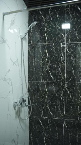 a bathroom with a black and white marble wall at Lotus Hotel Tashkent in Yakkasaray