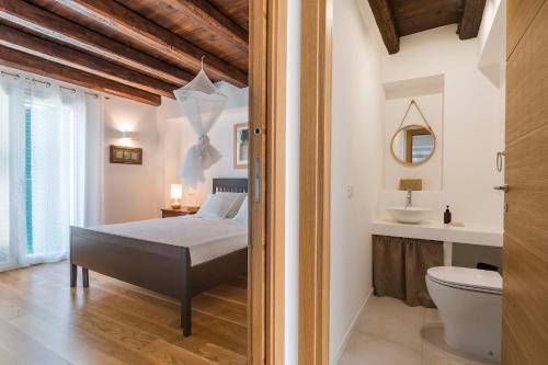 a bedroom with a bed and a sink and a toilet at Casita in Gratteri