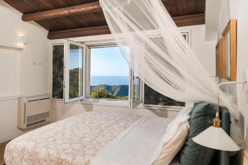 a bedroom with a bed and a large window at Casita in Gratteri