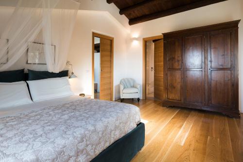 a bedroom with a large bed and a chair at Casita in Gratteri