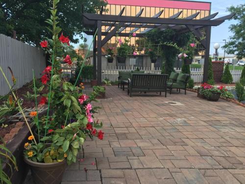 a patio with benches and flowers and a pergola at Affordable Suites of America Grand Rapids in Grand Rapids