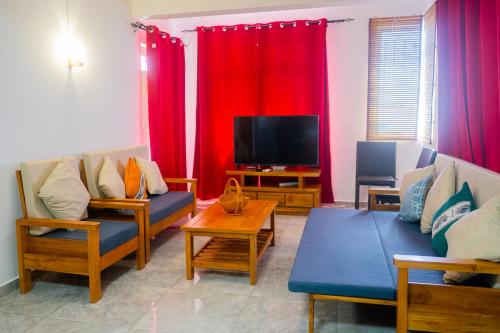 a living room with two couches and a flat screen tv at U & S Luxury Apartments Ltd in Quatre Bornes