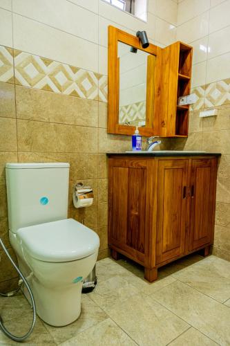 a bathroom with a toilet and a sink and a mirror at U & S Luxury Apartments Ltd in Quatre Bornes
