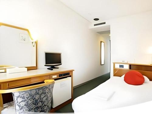 a room with two beds and a desk with a television at Pearl Hotel Mizonokuchi in Yokohama