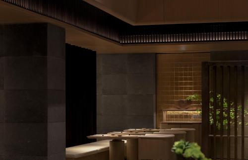 a dining room with a table and some plants at 徐州云东境酒店 in Xuzhou