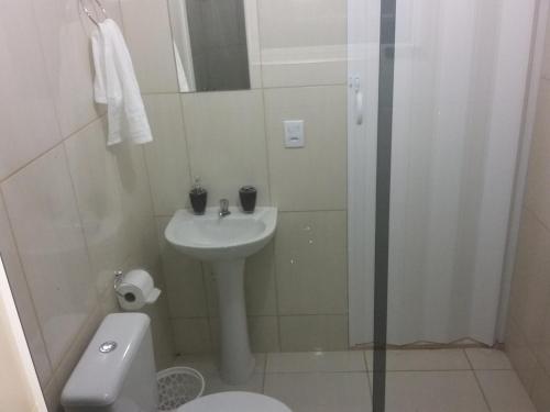 a bathroom with a sink and a toilet and a shower at Pousada Ancoradouro in Cananéia