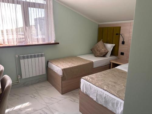 a small bedroom with two beds and a window at MargaryanS hotel in Yerevan