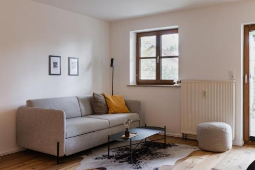 a living room with a couch and a table at HØV - Boutique-Apartments im Allgäu - Rückzug & Design in Altusried