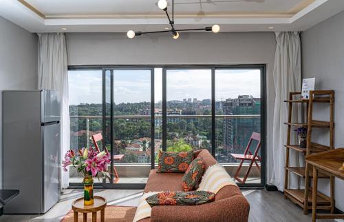 ナイロビにあるEscada Studio & 2-bedroom, Rooftop Swimming Pool, Gym, Workspace, Wonderiss Homes Westland Livingのソファと大きな窓のあるリビングルーム
