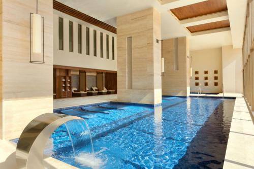 uma piscina de beiral infinito com uma cascata numa casa em Turquoize at Hyatt Ziva Cancun - Adults Only - All Inclusive em Cancún