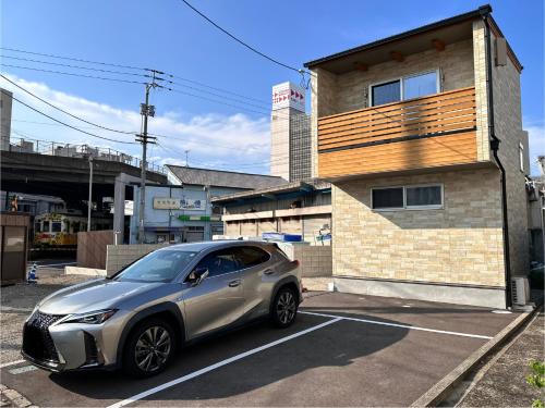a silver car parked in a parking lot in front of a building at 77kawaramachi 新築一軒家 in Takamatsu