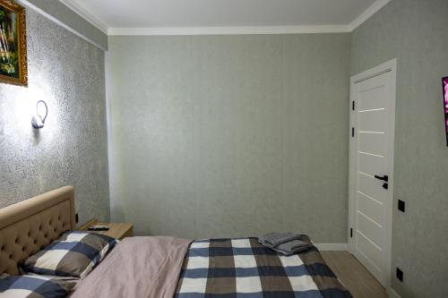 a bedroom with a bed with a blue and white blanket at Fine Airport 24h in Chişinău