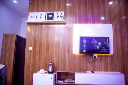 a room with a tv on a wooden wall at Ontario Suites in Lagos