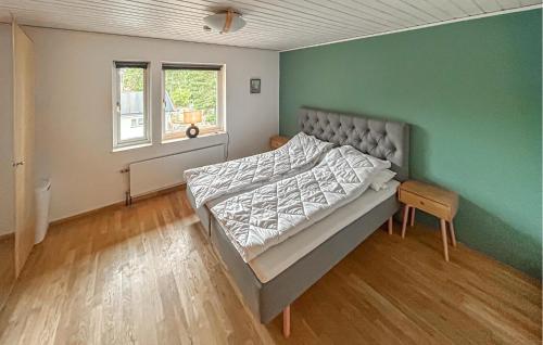 a bedroom with a bed and a green wall at Awesome Home In Åhus With Sauna in Åhus