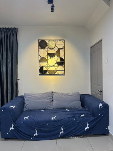 a blue couch in a living room with a painting at Ulike~home stay~Setia residen~4room in Kampong Selamat