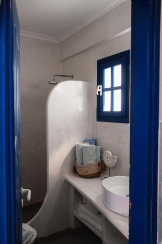 a white bathroom with a sink and a mirror at Roula Villa Studios & Apartments in Perissa