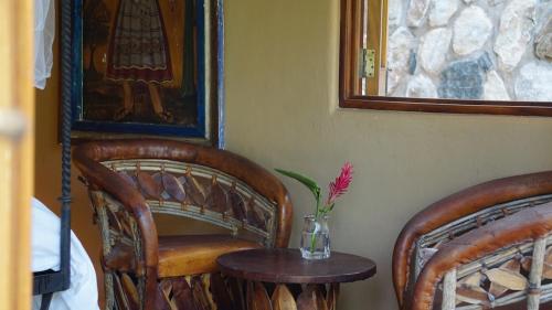 a room with two chairs and a vase with a flower on a table at Upper Casita Mi Media Naranja in San Francisco