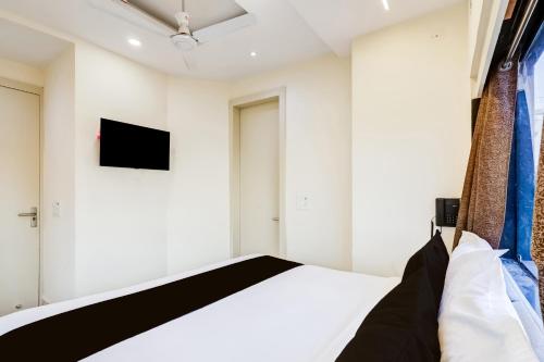 a bedroom with a bed and a tv on the wall at Hotel O Roux residency in New Delhi