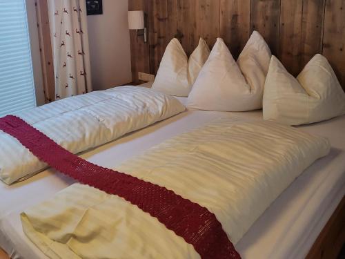 a bed with white pillows on top of it at Apartment in Neukirchen with a balcony in Neukirchen am Großvenediger