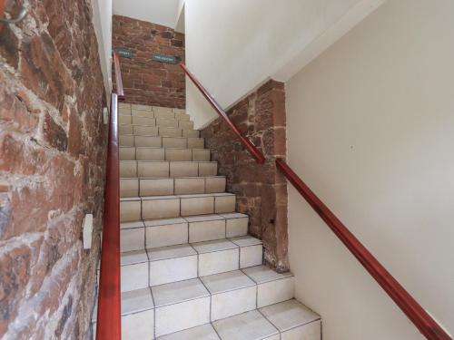 a staircase in a building with a brick wall at The Hayloft in Wigton