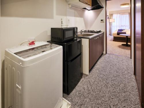 a kitchen with a dishwasher and a tv on top of it at &haku Kyoto Marutamachi in Kyoto