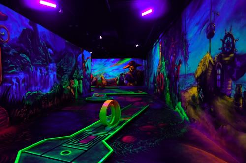 a dark room with green and purple lights at B&K Hotels in Vlotho
