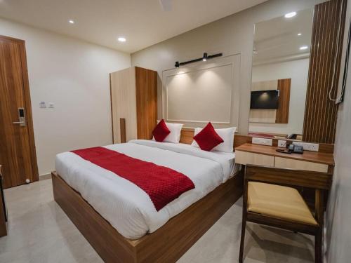 a bedroom with a large bed with red pillows at The Blessing Palace in Muzaffarpur