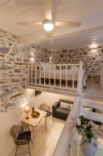 a living room with a staircase and a table and chairs at Vaporia seaview suites - Balcony suite in Ermoupoli
