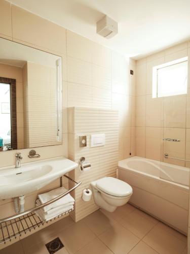 a bathroom with a sink and a toilet and a tub at Zaton Holiday Resort in Nin