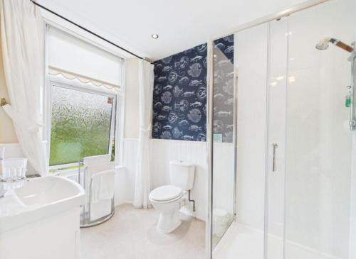 a bathroom with a toilet and a shower and a sink at Invergarry Room Only Guest House For Adults in Windermere