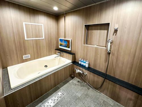 a bathroom with a tub and a shower at Hotel BaliBali 岩槻 in Saitama