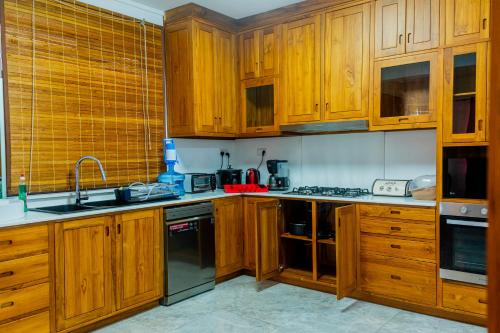 a kitchen with wooden cabinets and a sink at U & S Luxury Apartments Ltd in Quatre Bornes
