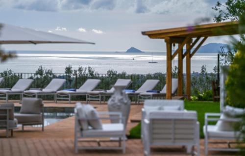 a row of white chairs and a row of tables and chairs at Gorgeous Home In Strettoia in Strettoia