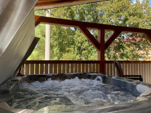 a hot tub on a deck with water at Elements Apartments & Renata in Božičany