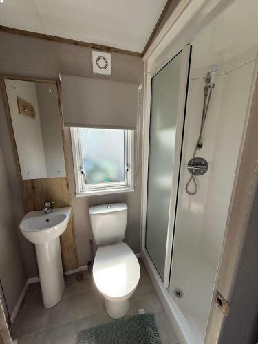 a small bathroom with a toilet and a sink at Rockley Park - Holiday Accommodation 22180 in Lytchett Minster