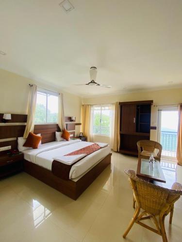 a large bedroom with a large bed and a table at Casa Nube Resort Munnar in Munnar