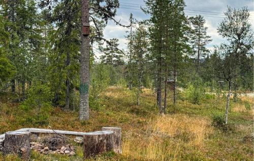 a wooden bench in a field with trees at Nice Home In Østby With House A Panoramic View in Østby
