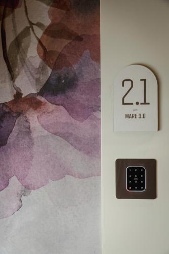 a clock on a wall next to a painting at Mode Eco Mood Hotel - Adults Friendly in Rimini