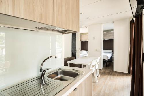 - une cuisine avec un évier et une table dans l'établissement Zaton Holiday Resort Camping Homes, à Nin