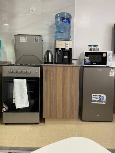 a kitchen with a stove and a water container at Affordable Studio - WIFI, Netflix & Parking in Kikuyu
