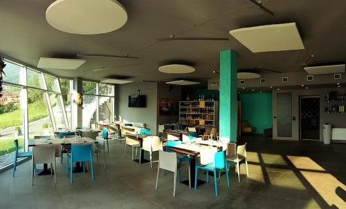 a dining room with tables and chairs and windows at Vela di Soleville camere con e senza vista lago con ristorante & pizzeria in Sale Marasino