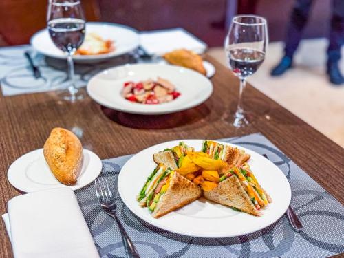 a table with plates of food and glasses of wine at Hotel Jardines de Uleta Suites in Vitoria-Gasteiz