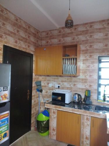 a kitchen with wooden walls and a counter with a microwave at Gigiswhitehouse in Cardoso