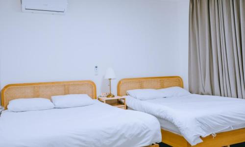 two beds sitting next to each other in a room at Chuncheon bali 376 