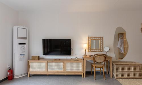 a living room with a television and a desk and chair at Chuncheon bali 376 