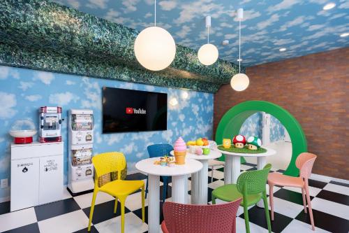 a dining room with tables and chairs and a tv at JAPAVISTA Unlimited in Osaka