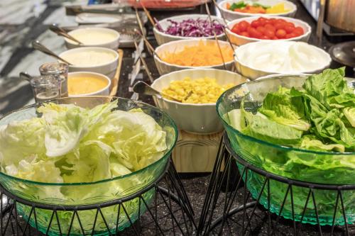 a table topped with bowls of vegetables and other dishes at Best Western Ratchada Hotel in Bangkok