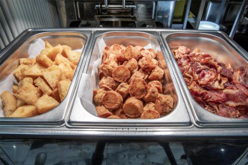 a buffet of different types of food in trays at Best Western Ratchada Hotel in Bangkok
